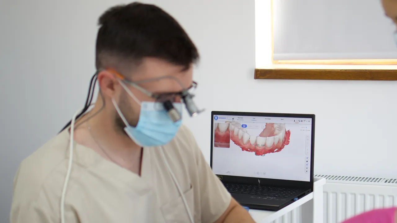 Scanare intraorală, cu modelul digital al arcadei pe ecranul laptopului